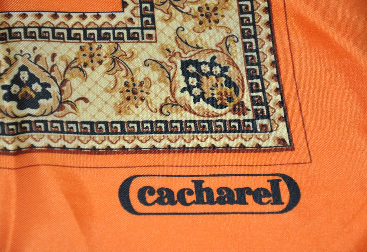 Cacharel bold tangerine silk scarf is bordered with a floral print finished with hand-rolled edges measuring 21