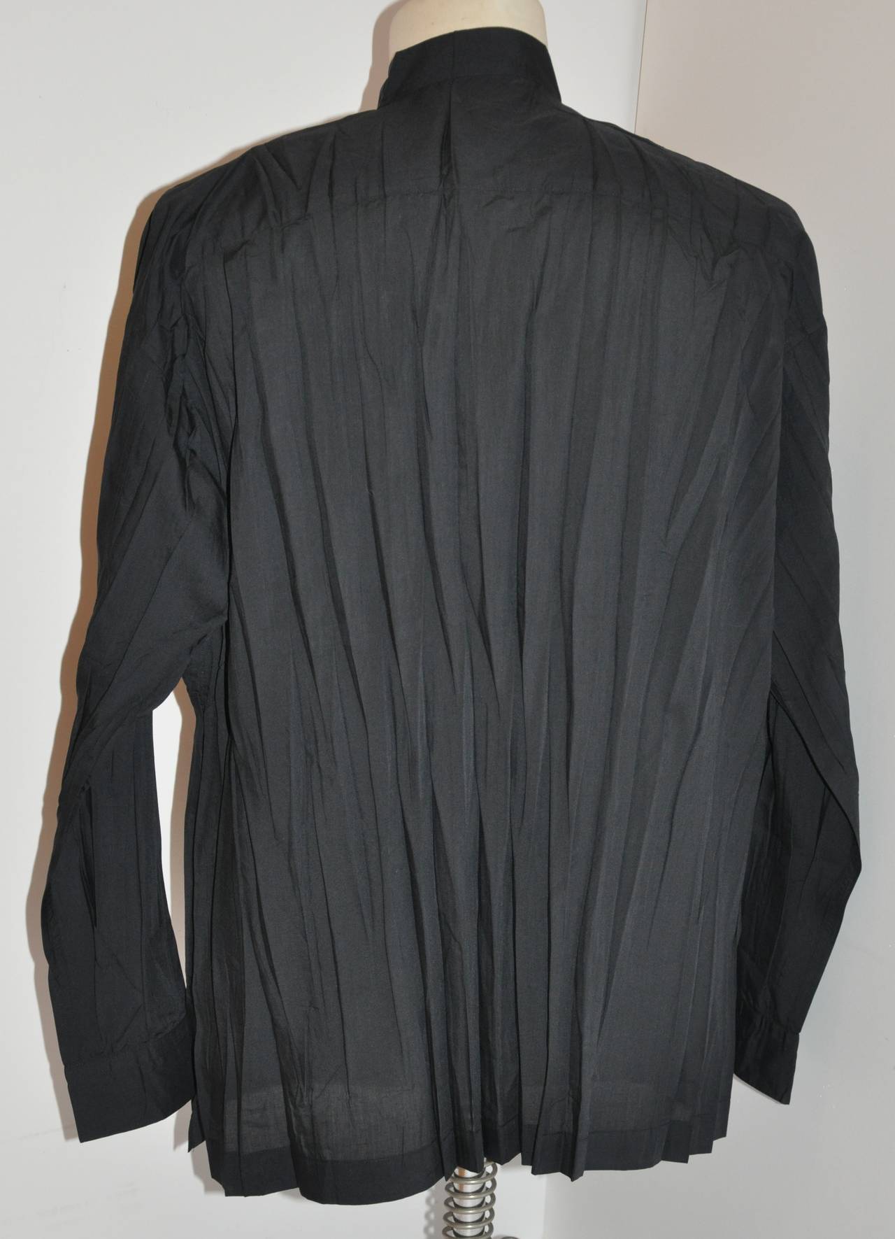 Dieses wunderbar bequeme Issey Miyake Hemd für Herren ist mit sieben (7) Perlmuttknöpfen auf der Vorderseite des Hemdes sowie an den Ärmelmanschetten und der vorderen Brusttasche verziert. Das Hemd hat auch zwei Seitenschlitze, die 4 1/8
