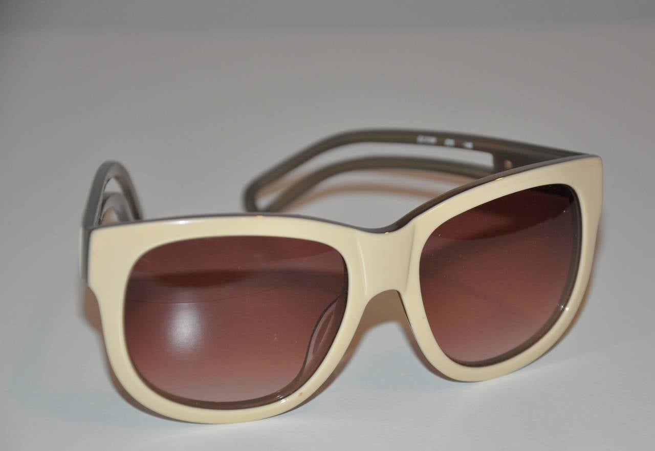 Chloe cream and smoked lucite sunglasses are accented with double-arms combined into one. The front measures 5 1/2