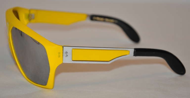 This bold banana-yellow lucite mirrored lens sunglasses has black lucite tips on the arms along with gold hardware.
   Height measures 2 1/8