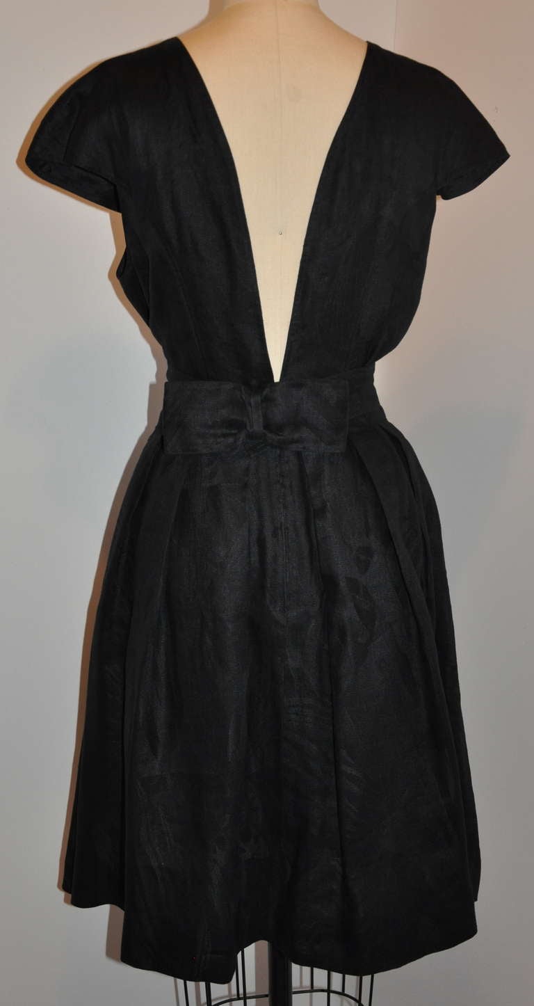 This wonderfully black linen dress features a plunging back side that's both sexy yet elegant at the same time. Fully lined with silk organza, the exterior linen has a print-on-print design. The bodice is detailed with silk lining while the skirt