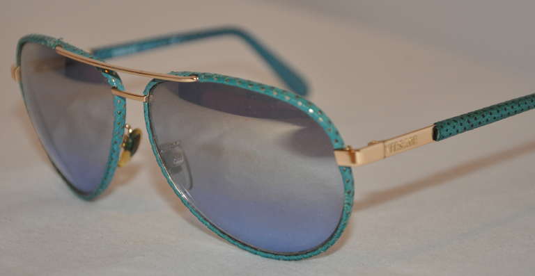 Diese wunderbare Sonnenbrille von Versace mit verspiegelter goldener Hardware ist mit schildpattfarbenem Lammleder überzogen.
   Die Länge über die Vorderseite misst 5 3/4