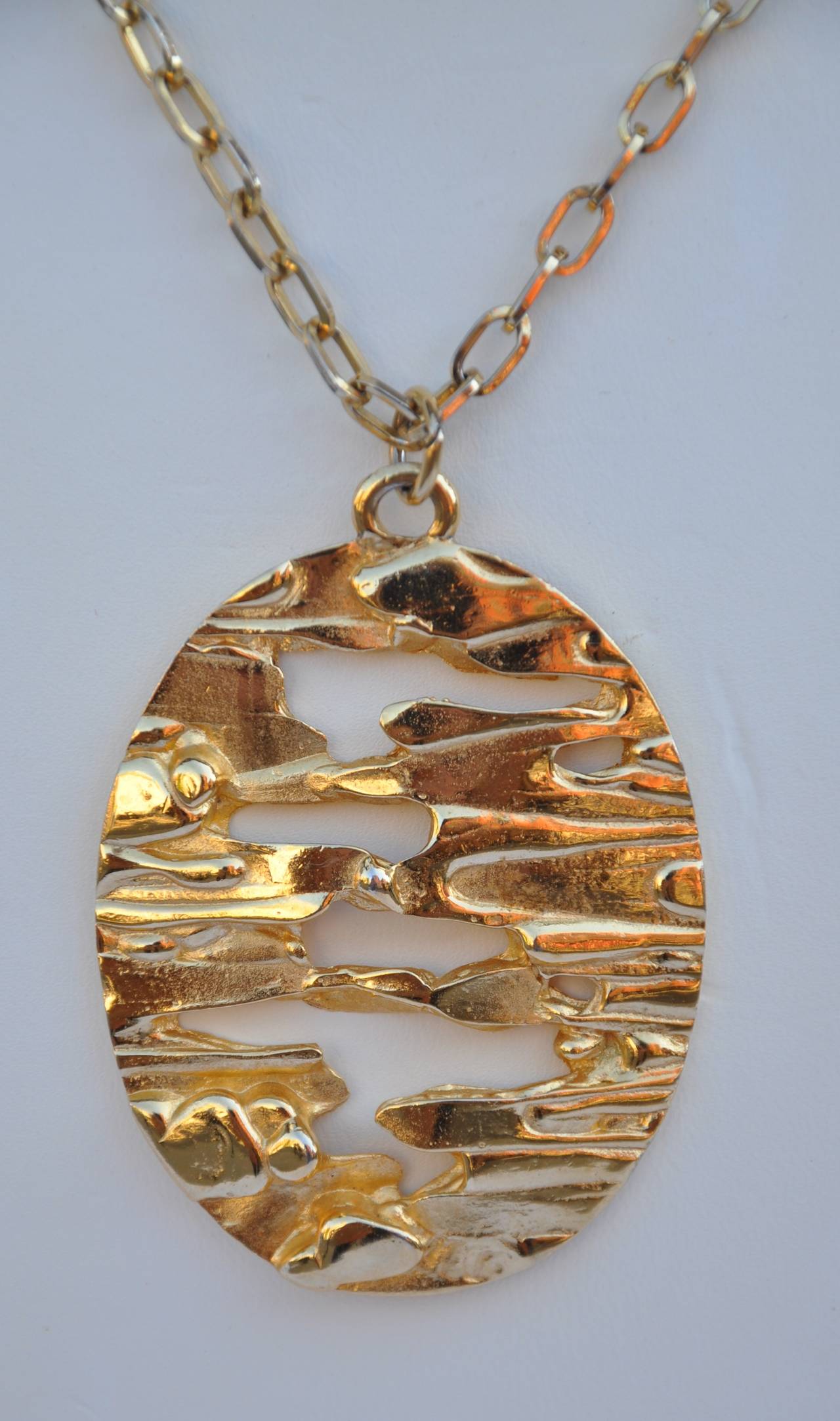         This wonderful huge Trifari gilded gold vermeil finish whimsical bold abstract pendant measures 1 6/8" in length, 2 3/8" in height and 2/8" in depth. The necklace measures 24" in total length. The pendant is signed on the