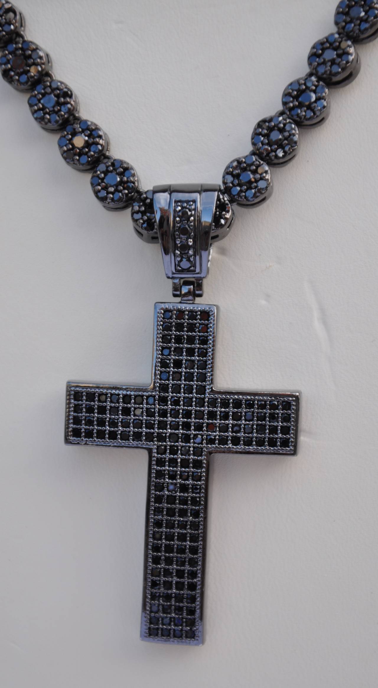        Kenneth Jay Lane's wonderfully wicked Large cross & necklace is encrusted with smoked rhinestones on both the pendant and necklace set in smoked polished hardware. The length of the necklace measures 31 3/4", width is 2/8",