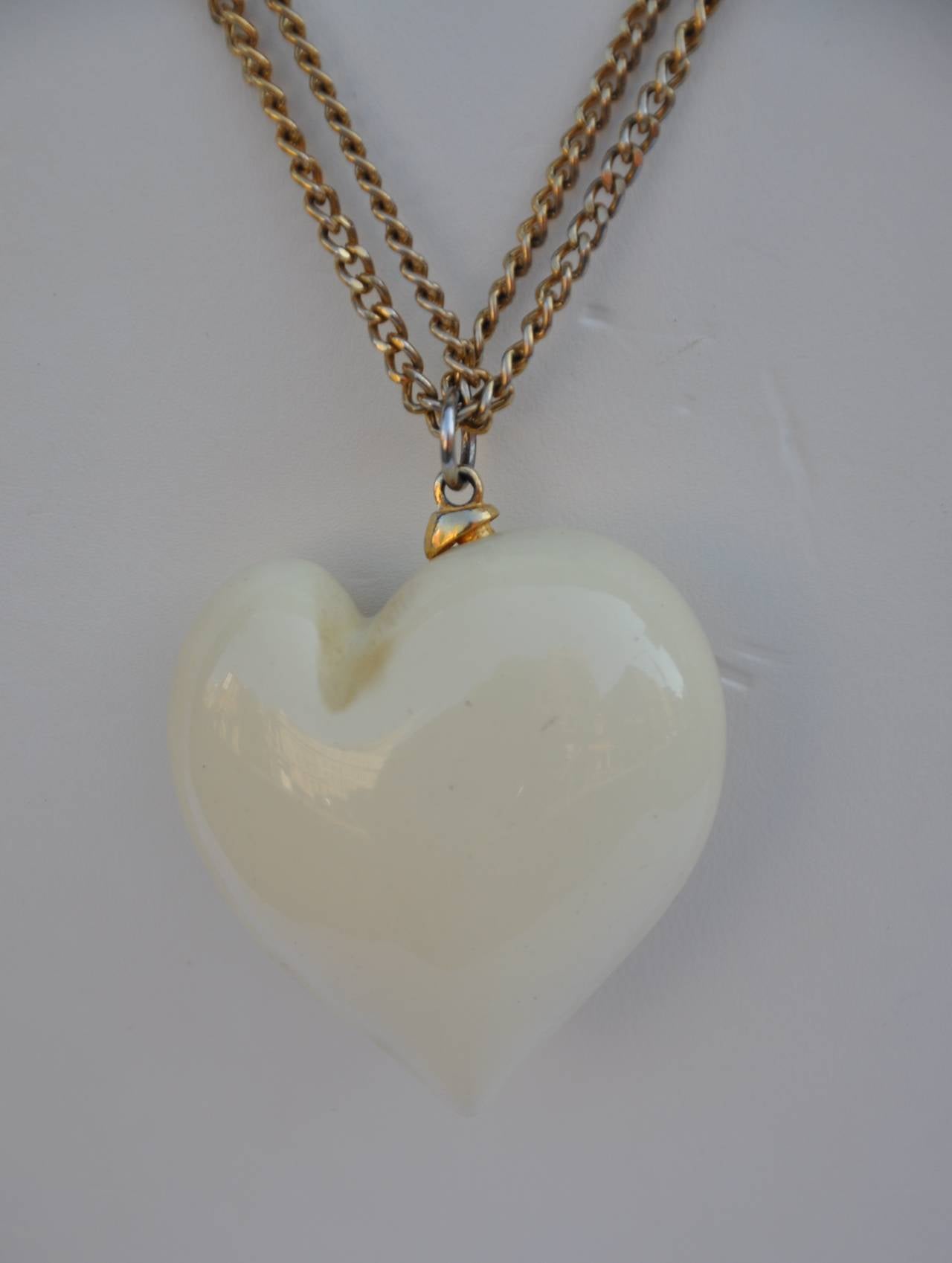        Kenneth Jay Lane, who recently left us, created this wonderful elegant huge cream lucite heart is signed accented with a gold tone link necklace. The heart measures 1 6/8" in width, 1 6/8" in length and 7/8" in depth. The