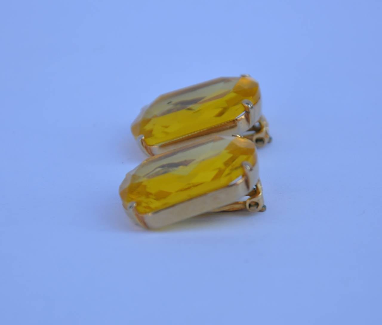 Schiaparelli's wonderful large gilded gold accented with canary-hue ear clips measures 7/8" in length, 1 1/8" in height and 3/8" in depth. Earrings are signed on the backside.