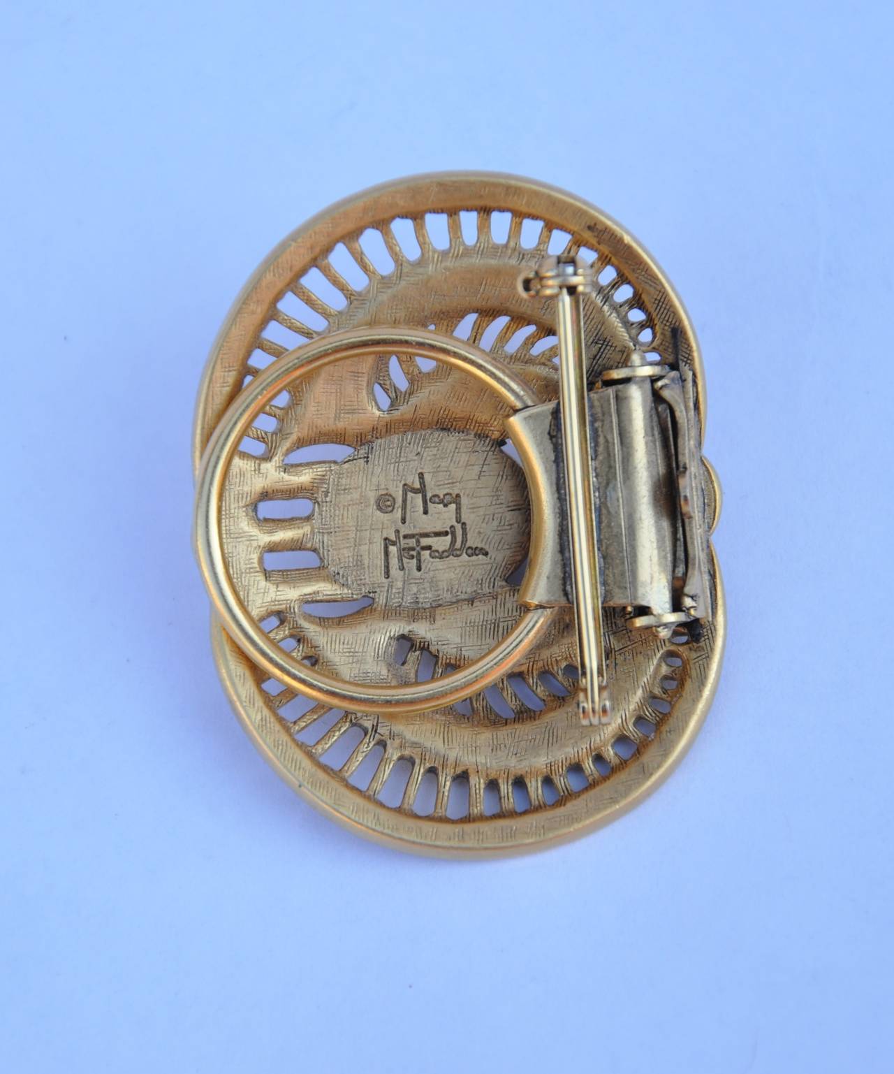 Rare Mary McFadden Egyptian Brooch/Clip is wonderfully carved in details with the gold hardware base. This piece measures 2" in length, 1 1/2" in height and 3/8" in depth. The backside of this brooch is signed.
