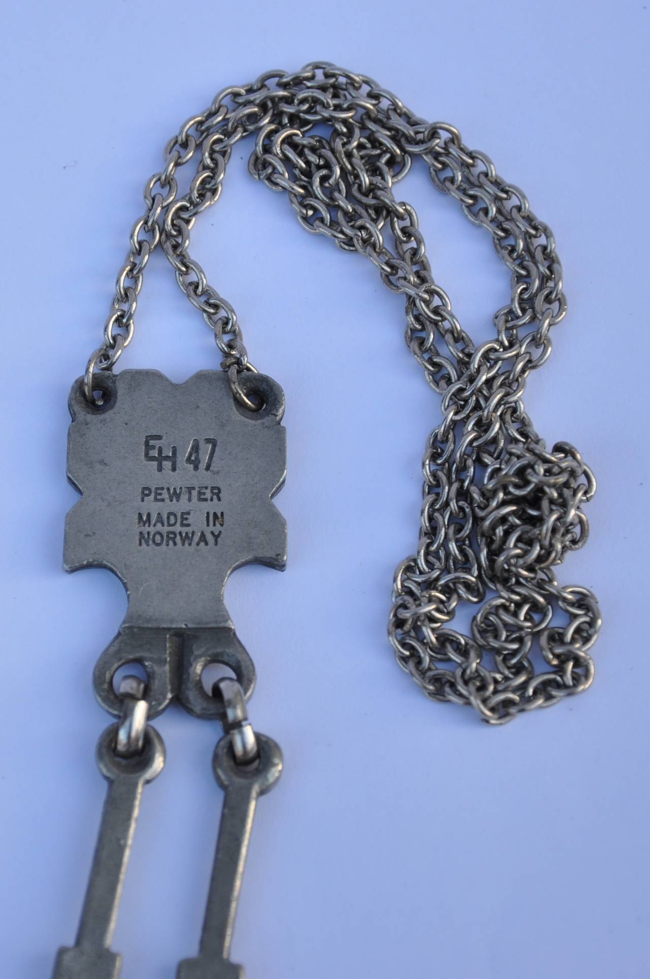 EH 47, made in Norway pewter necklace is combined with a wonderfully designed dangling pendant. Signed and engrave with "EH 47, Pewter, Made in Norway". The necklace measures 28" in length. The pendant measures 1" x 4".