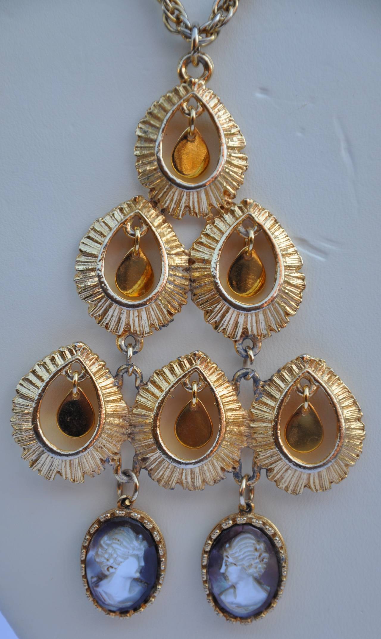        This huge delightful mobile pendant with necklace features two mother-of-pearl cameos dangling under multiple small gold pedals. The huge pendant measures 4