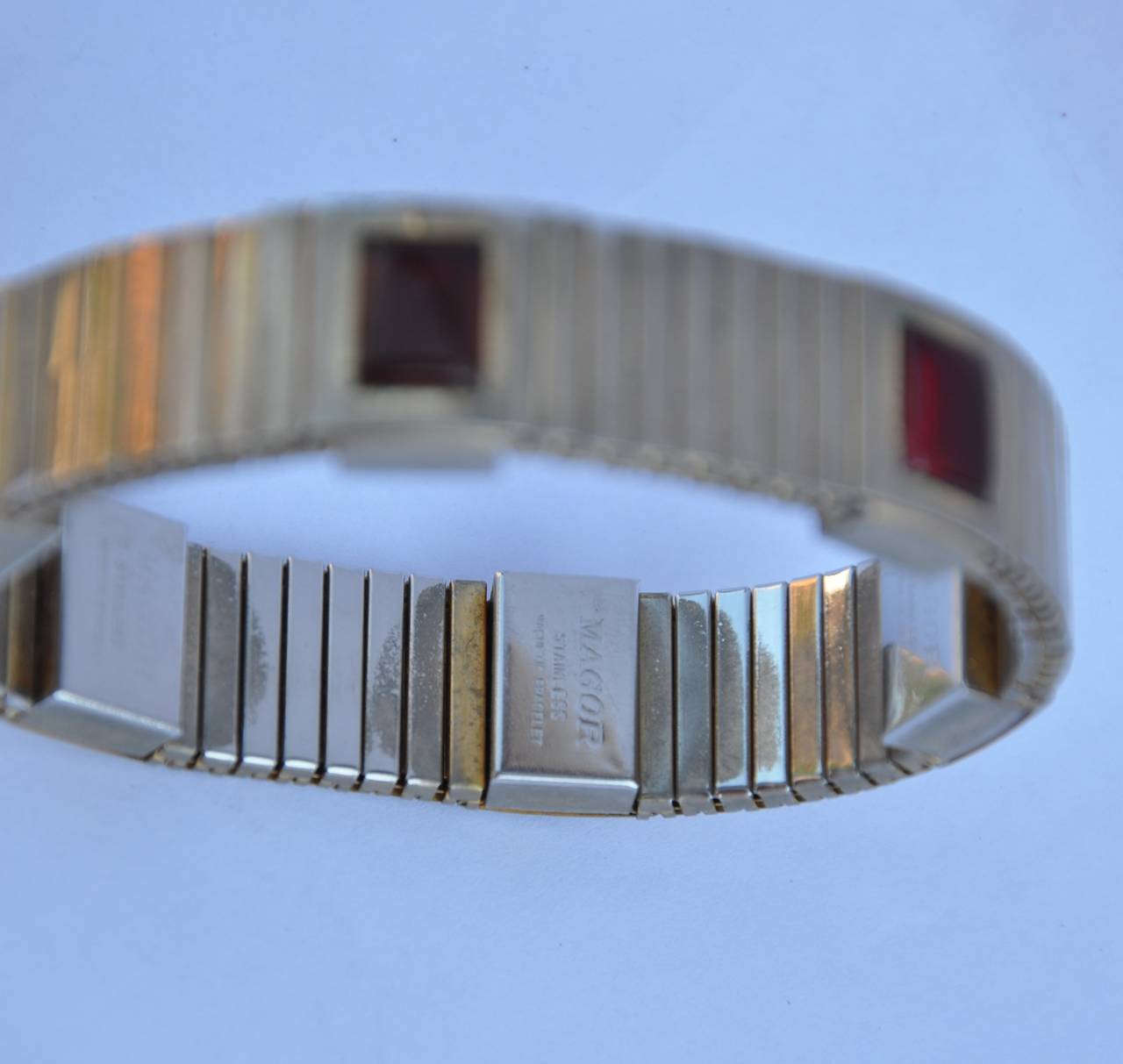 Magor stainless with multi ruby resin magnetic bracelet is adjustable. Without wearing, the circumference measures 8 1/2", width is 5/8", depth is 2/8".