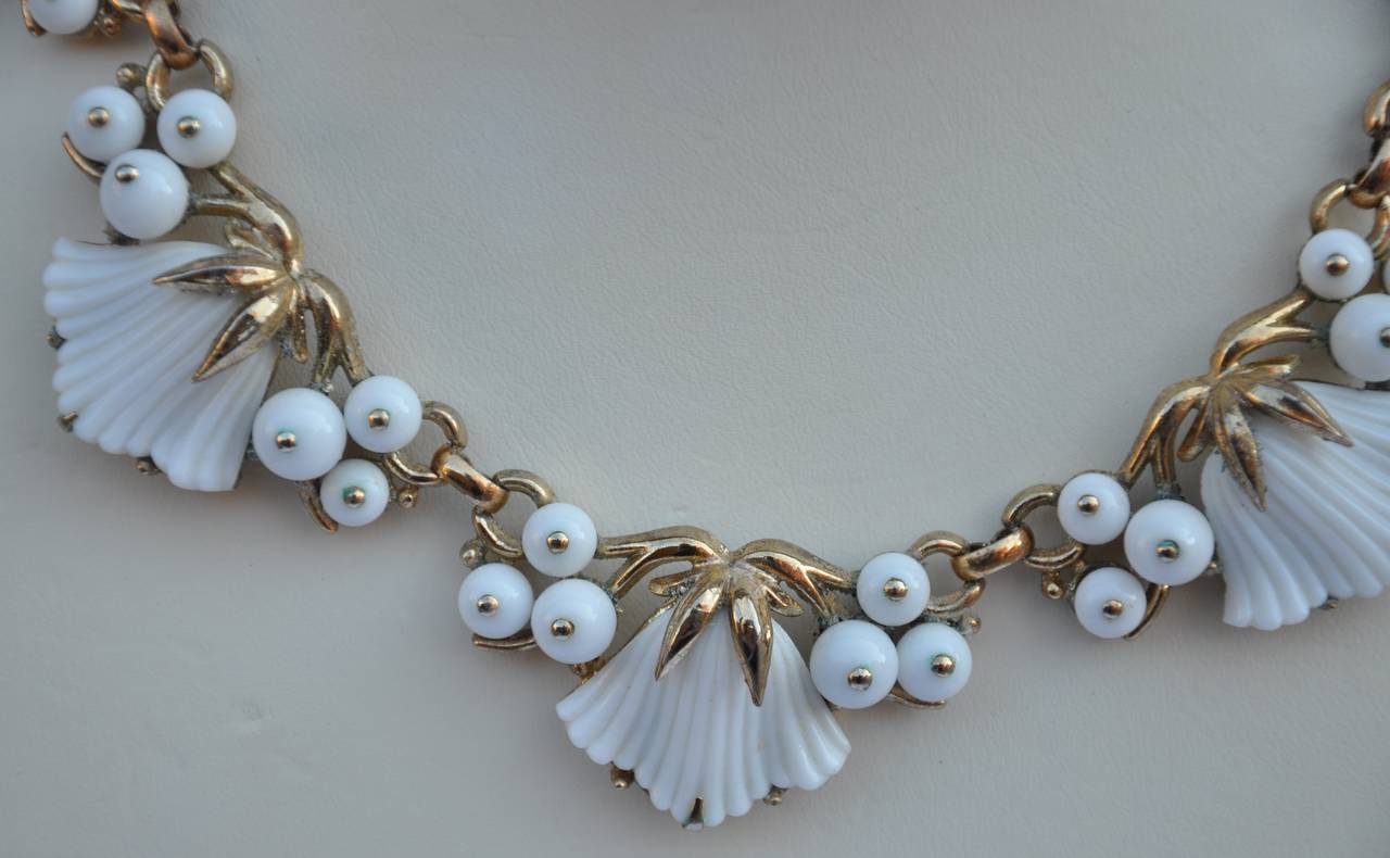 Trifari wonderful white pour glass is combined with gold hardware as well as white glass beads. The length measures 13", with 2 3/4" chain to lengthen if desired. The width measures 1". Necklace is signed along the backside.