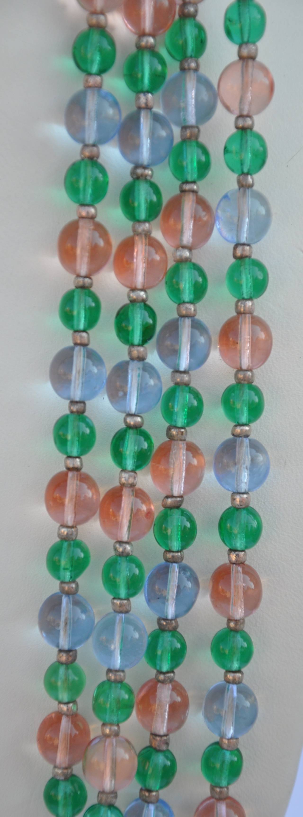 This wonderfully multi-color pair of necklaces with glass beads made in West Germany measures 60" in length. The thicken of the beads range up to 1/4" with multiple colors of greens, pinks and clear. Both pair of necklaces measures the