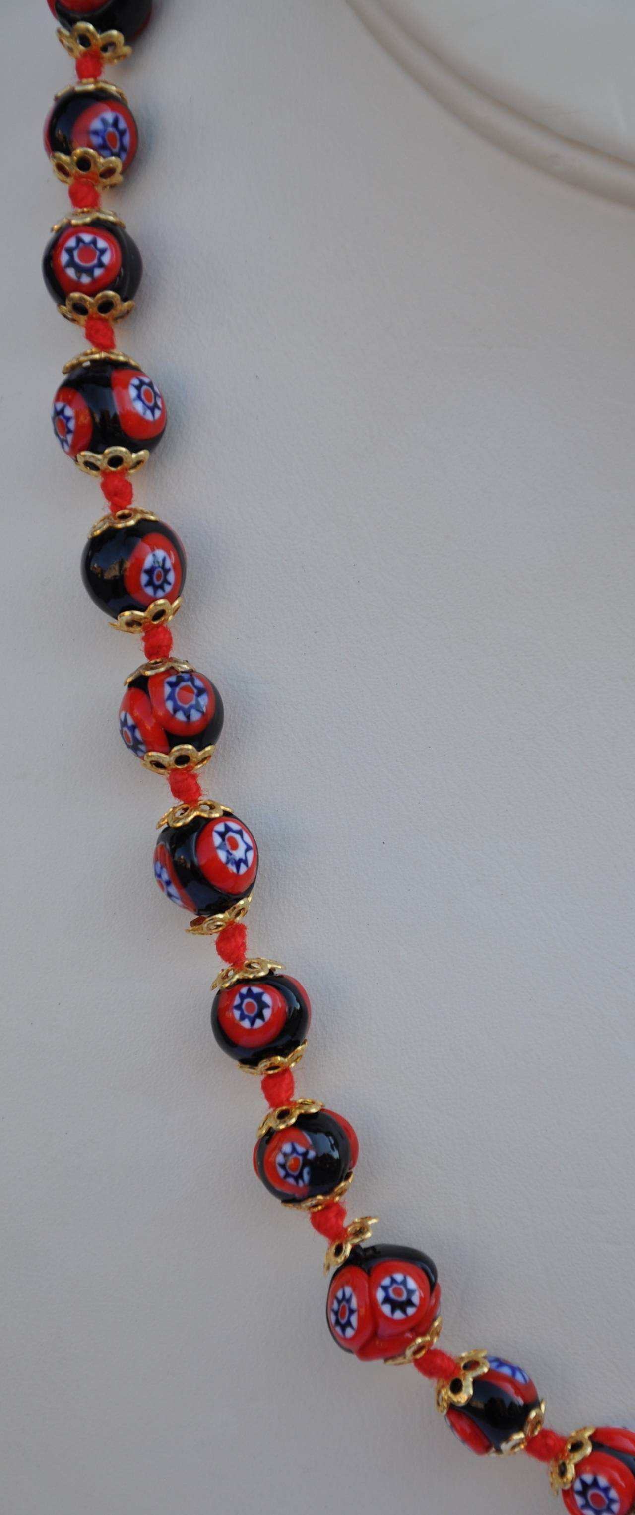Multi-colors blended with navy, red and white in each glass carved beads makes for a lovely necklace. The necklace measures 19" in length with a circumference up to 3/8".