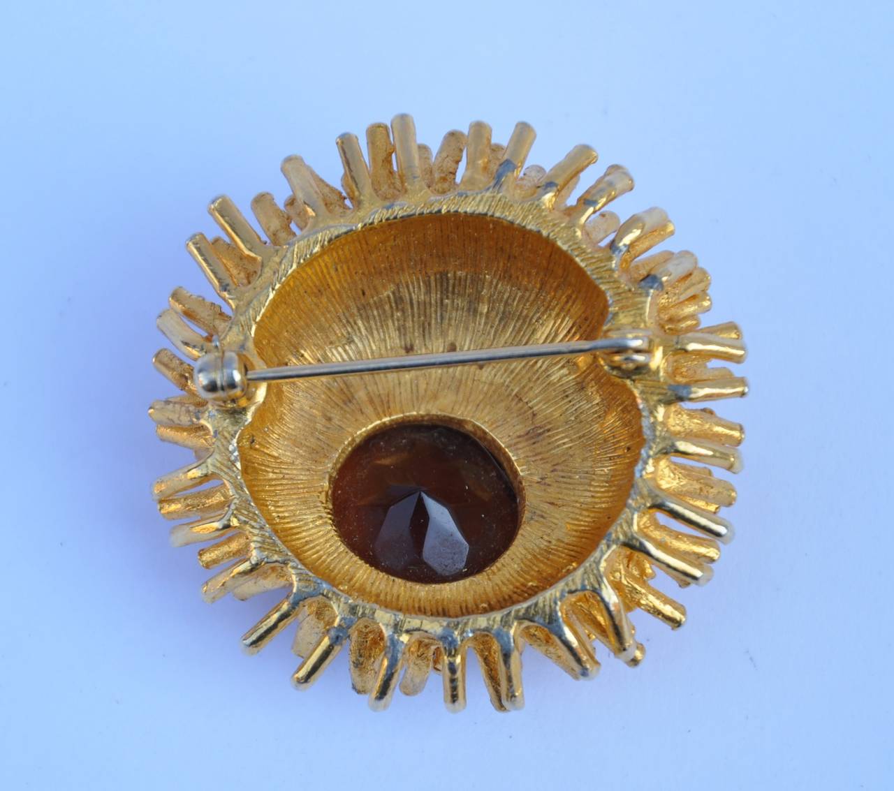         This wonderful impressive large gilded gold hardware brroch is accented with a large center stone. The brooch measures 1 5/8