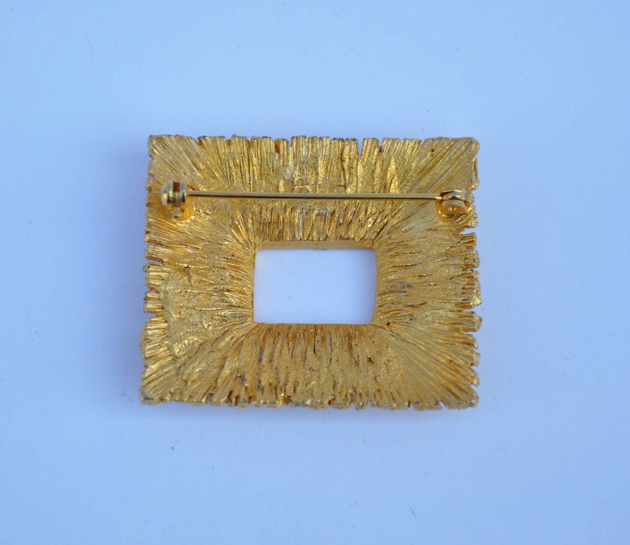 Gilded gold hardware "Frame" brooch measures 1 5/8" in length, 1 2/8" in width and 3/8" in depth.