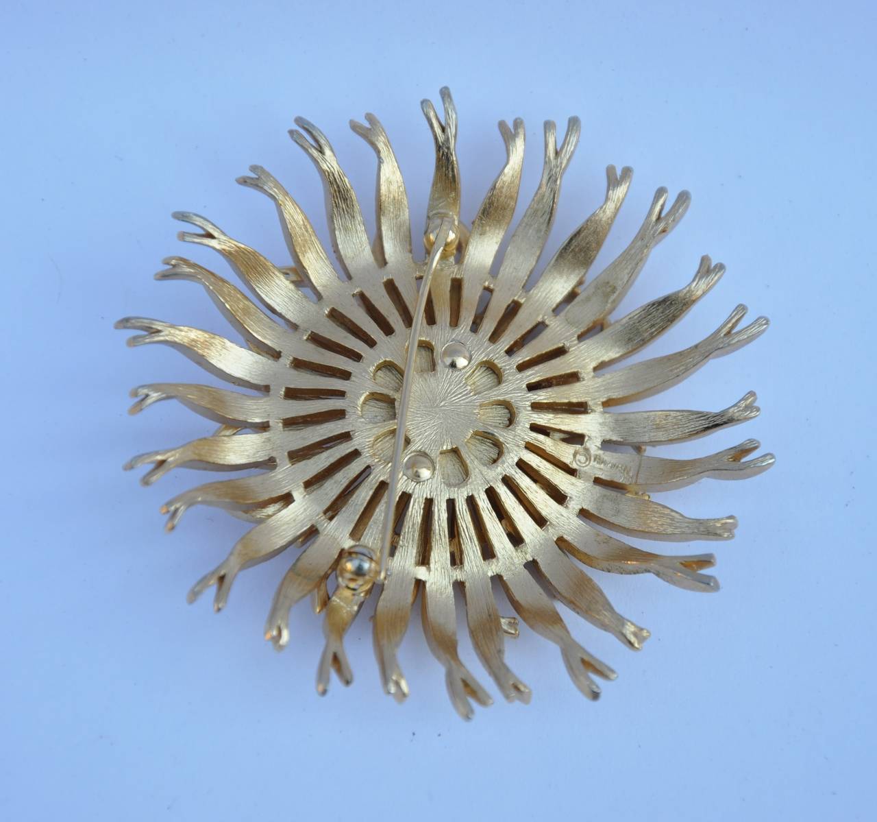 Trifari huge "Floral" gold-tone brooch is signed in the signed and measures 2 1/2" in circumference with a depth of 1/2" .