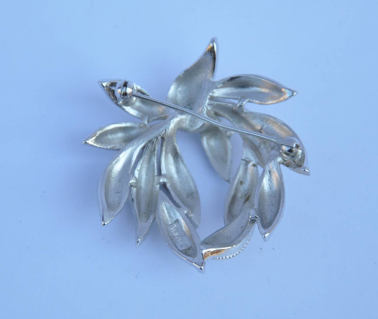 Trifari silver tone "wreath" brooch is signed on the backside and measures 1 3/4 in width, length is 1 3/4", depth is 1/4".
