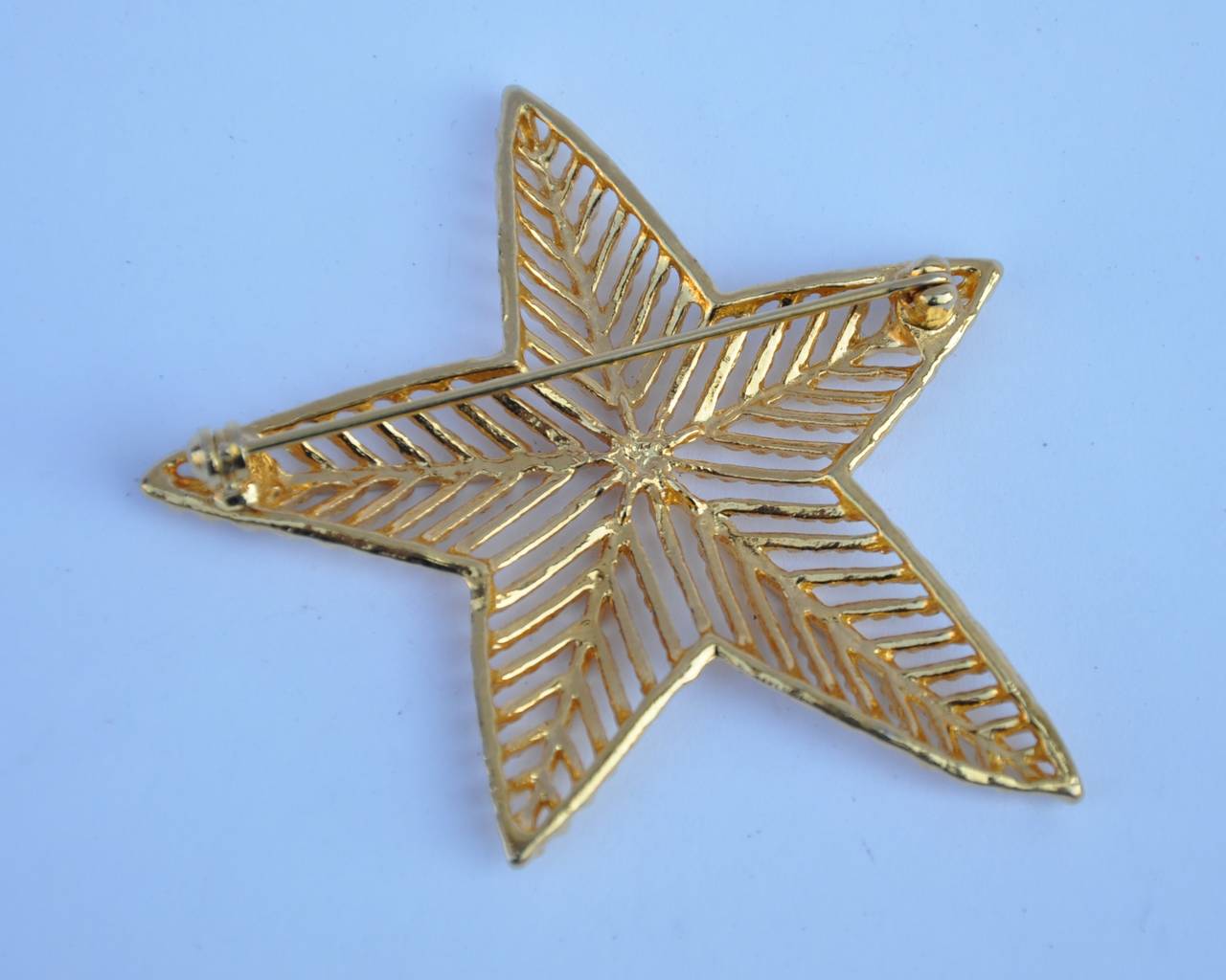 This wonderful gilded gold vermeil finish "Shining Star" brooch measures 2 3/8" in length across, 2 1/4" in height and 2/8" in depth.
