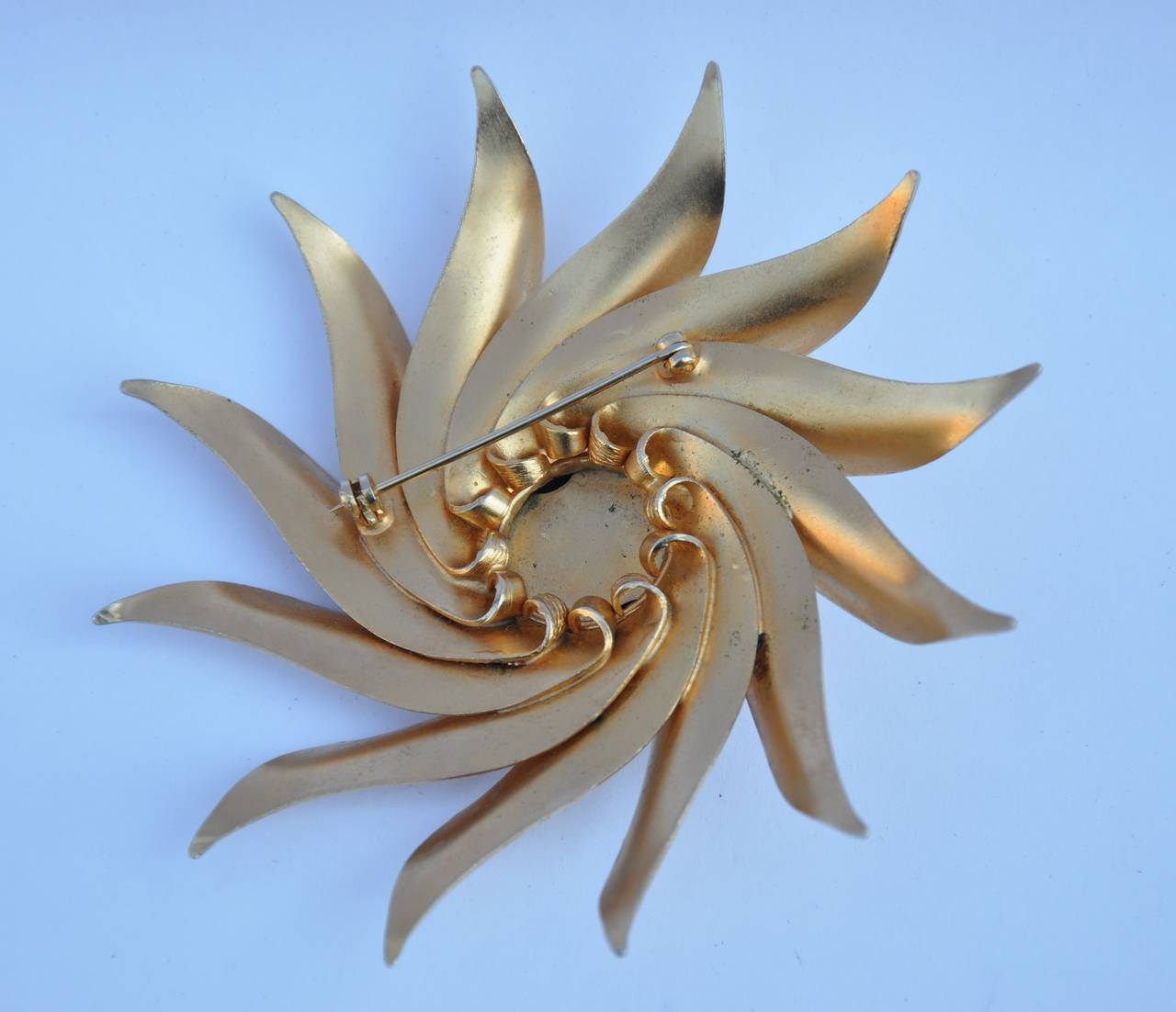 This huge bold "starburst" gold-tone hardware brooch measures 3 1/4" in total circumference and 1/2" in depth.