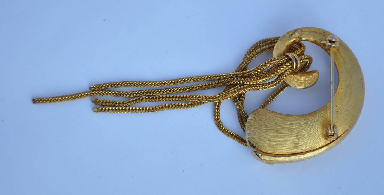 Gilded gold hardware with "Hanging Chains" brooch measures 4" in length, 1 6/8" in width and 3/8" in depth.
