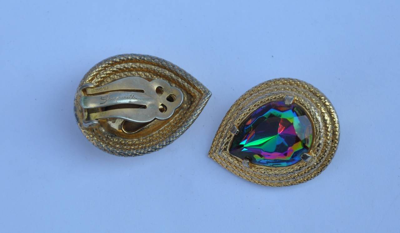        Schiaparelli wonderfully detailed gild gold vermeil finish with filigree detailing is set with a iridescent glass center. The length measures 7/8", height is 1 1/8", depth is 2/8". Earrings are signed on the backside.