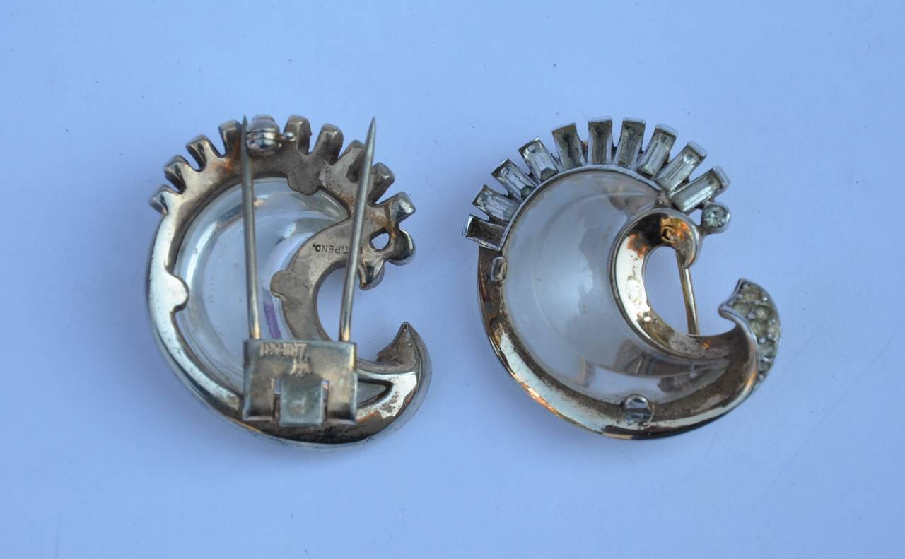 Trifari's wonderfully detailed lucite with multi-size of rhinestones set in gilded gold hardware. Set of two, these brooches can be used as sweater clips, shoe clips, or to simply accent hats. Signed on the back side, these brooches measures 1