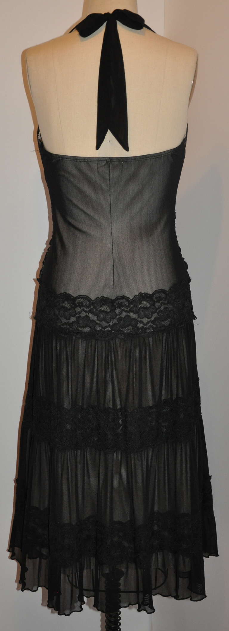 This elegant, yet sexy black lounge dress has three (3) tier of net and lace combination. Nylon and spandex makes for a perfect fit over one's curves. B-Cup on the breasts and accented with a 18