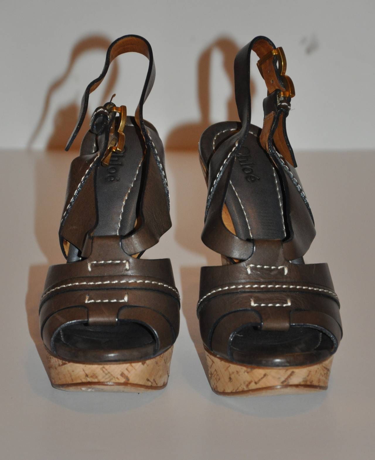 Chloe's wonderful wedge sandals are in a warm-brown calfskin with detailed top-stitching as well as gold hardware accented on the buckles. The heel measures 5 2/8