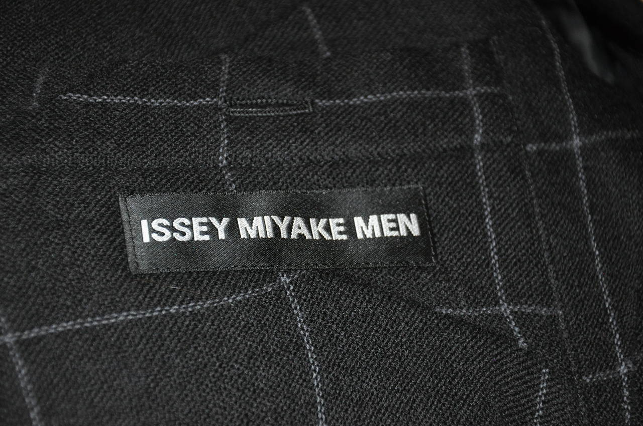 Issey Miyake wonderfully wicked men's black wool plaid deconstructed plaid jacket is size 5. A work of art, multi-patched first to form his signature deconstructed magic, this jacket is a must! The front features three (3) buttons as well as two (2)