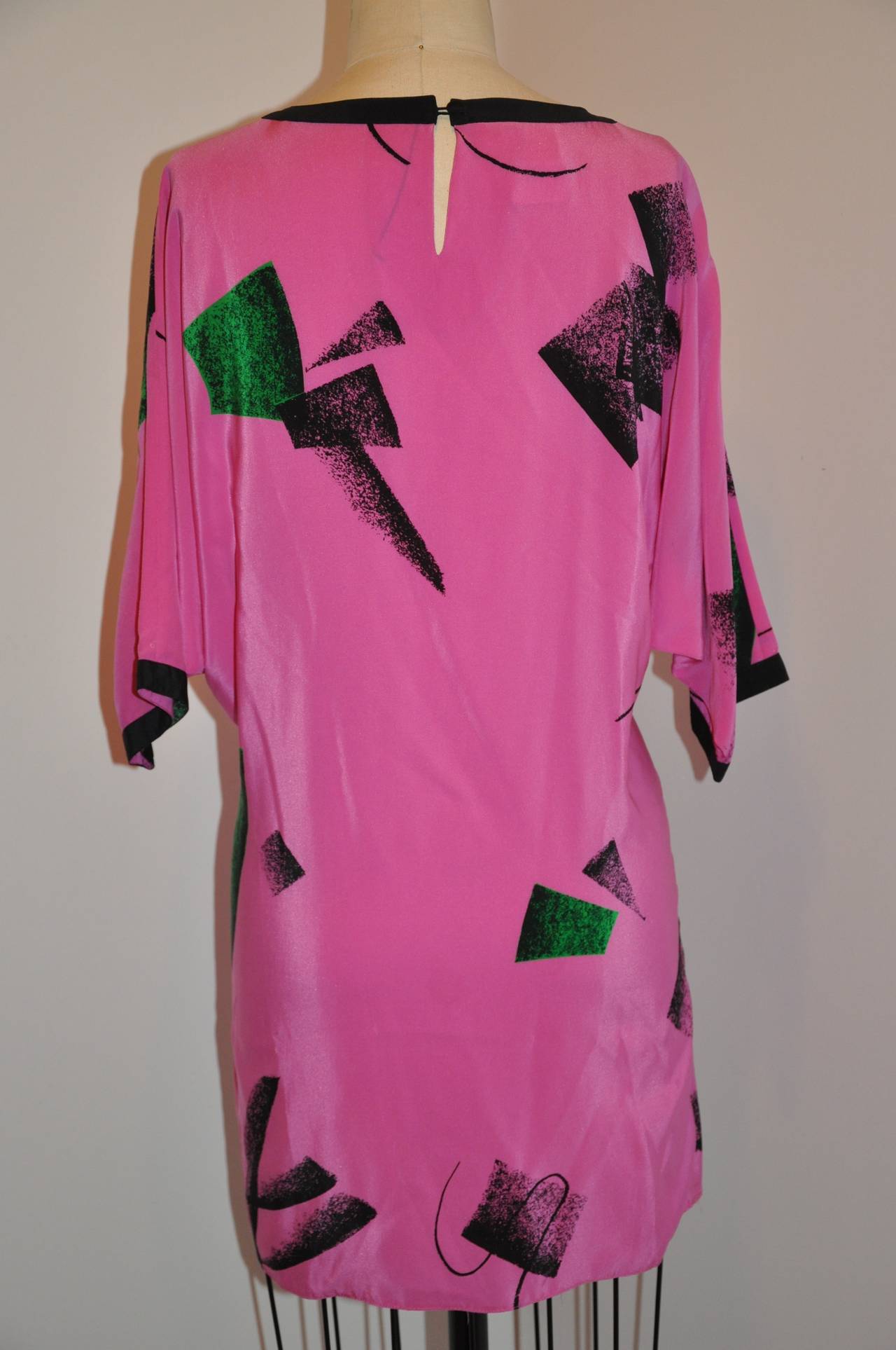 Flora Kung Bold fuchsia and Black abstract print silk tunic is accented with black along the neckline and sleeve's cuffs. The underarm circumference measures 46