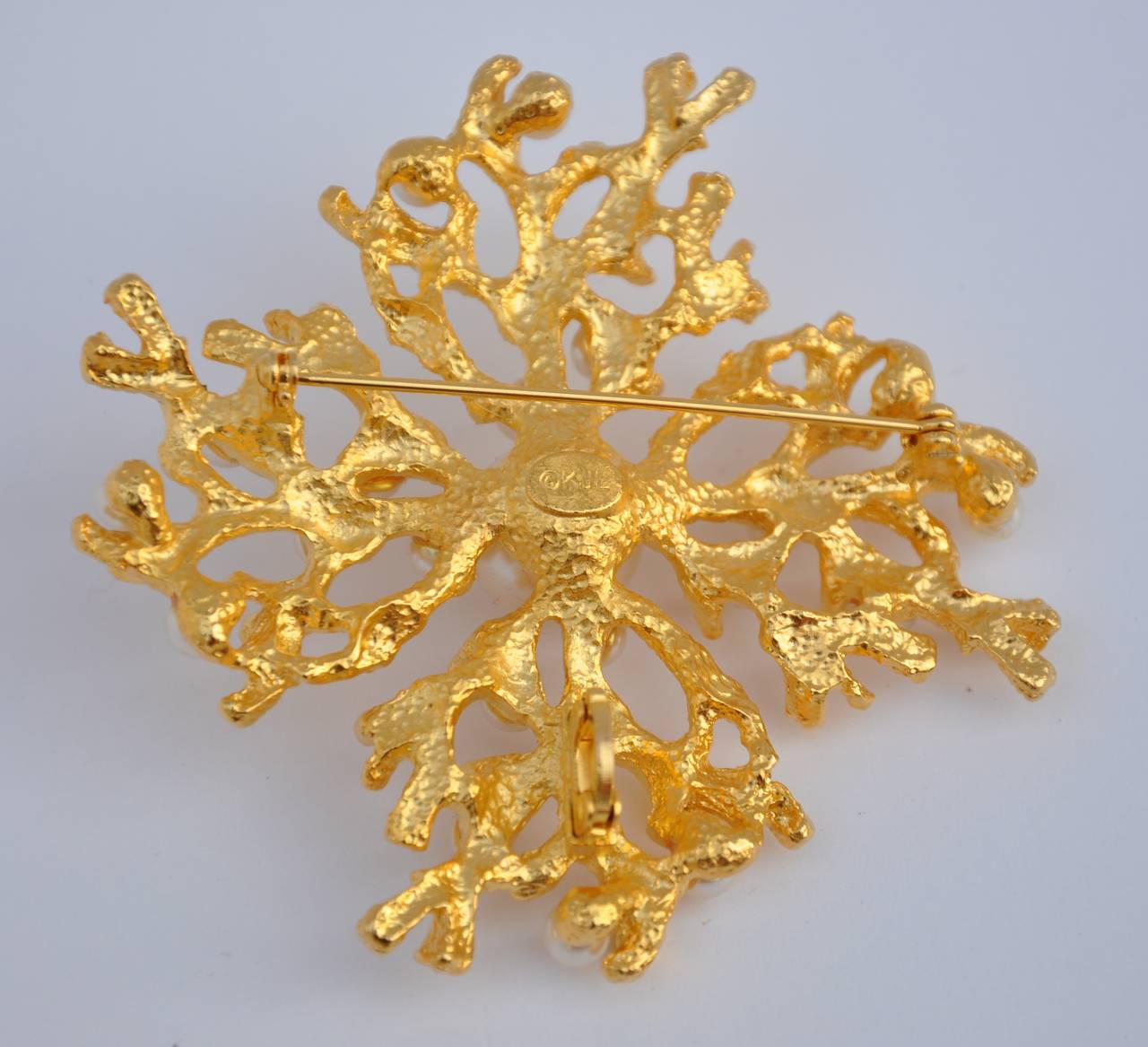 The famed Kenneth Jay Lane, who recently left us, created this wonderfully huge gilded gold vermeil finish brooch is paired with pearls, measuring 3" in length. The width measures 3" and the depth is 5/8".