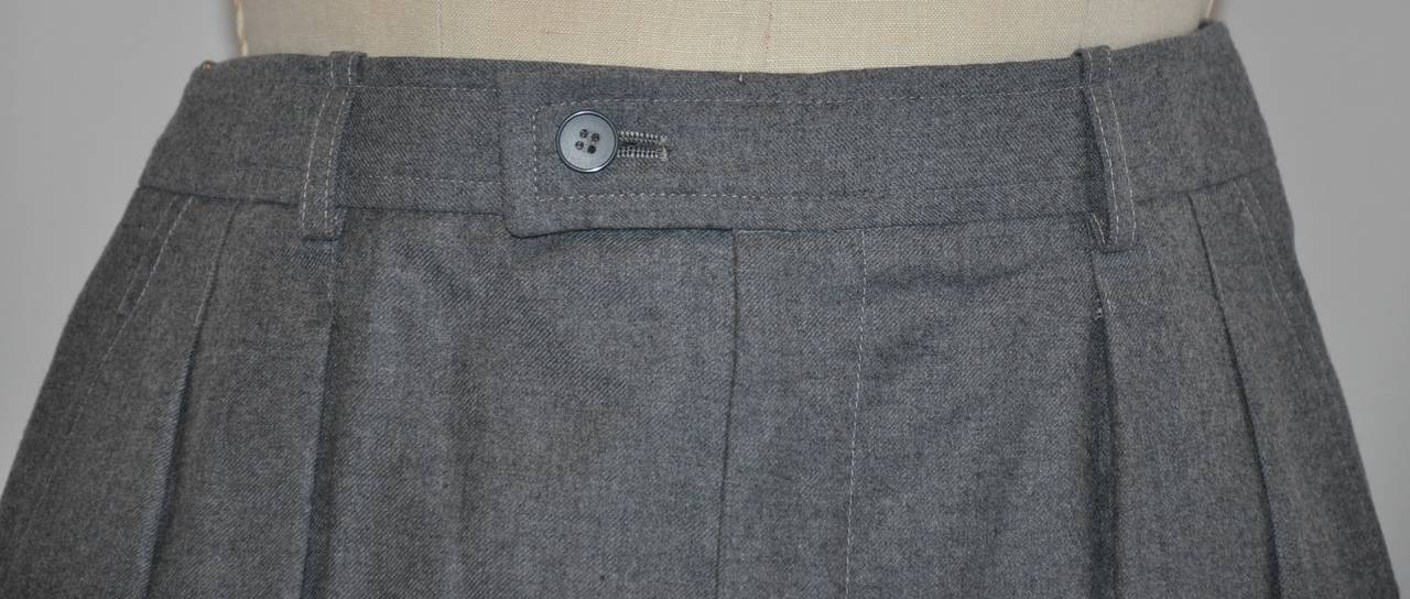 Yves Saint Laurent charcoal gray wool trousers has four pleats as well as two set-in pockets.
          The waist measures 28