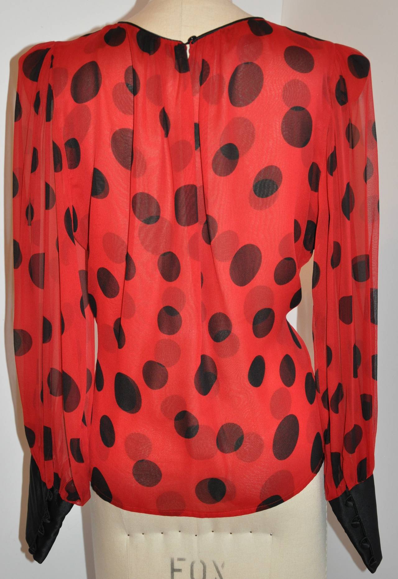 Flora Kung wonderfully detailed silk chiffon blouse is double-layered. Red with black polka dots, this wonderful blouse is accented with black silk crepe de chine piping along the neckline and the sleeve's cuffs. The cuffs has four silk covered