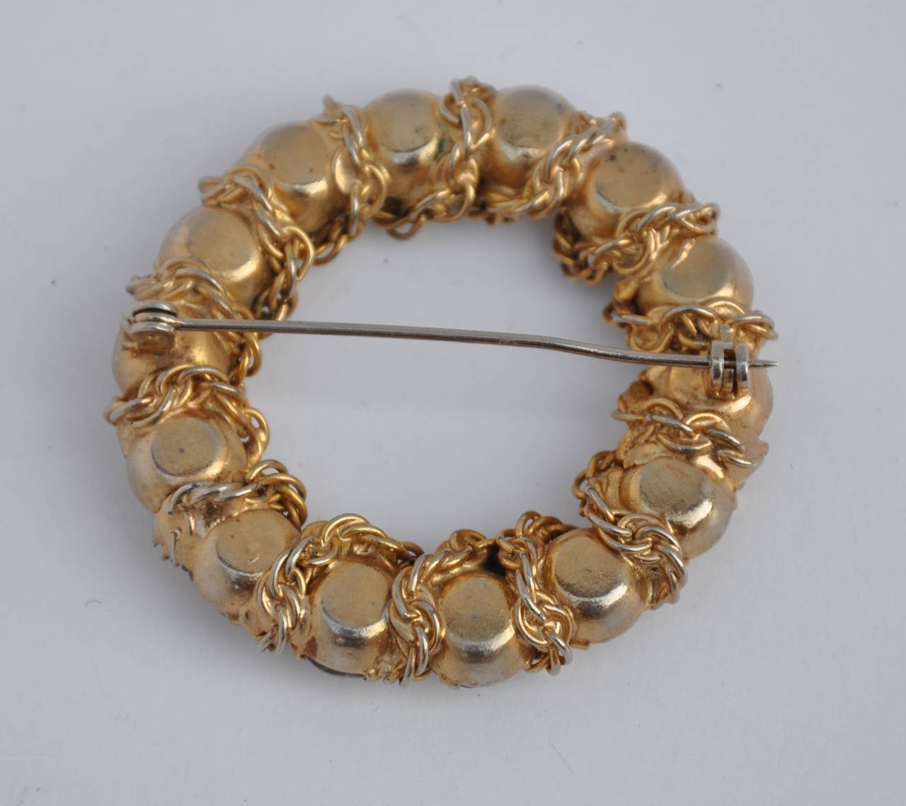 Bold gilded gold "Chain-Link" hardware brooch is accented with rhinestones. This large circular brooch measures 1 7/8" in circumference, width and depth measures 1/2".