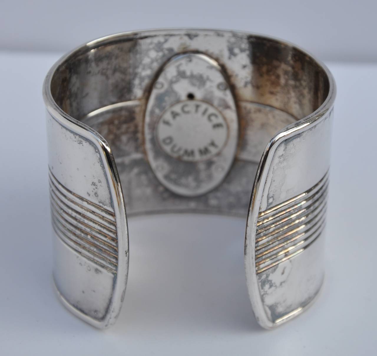 Jean Paul Gaultier bold wide heavily silver plated cuff is accented with hie signature logo which opens up as a 