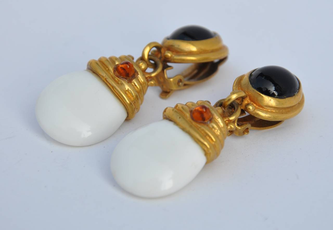         These thick gold vermeil drop earrings are accented with white and black lucite as well as amber-like seed drops. The length measures 2", width is 6/8" and the depth is 3/8".