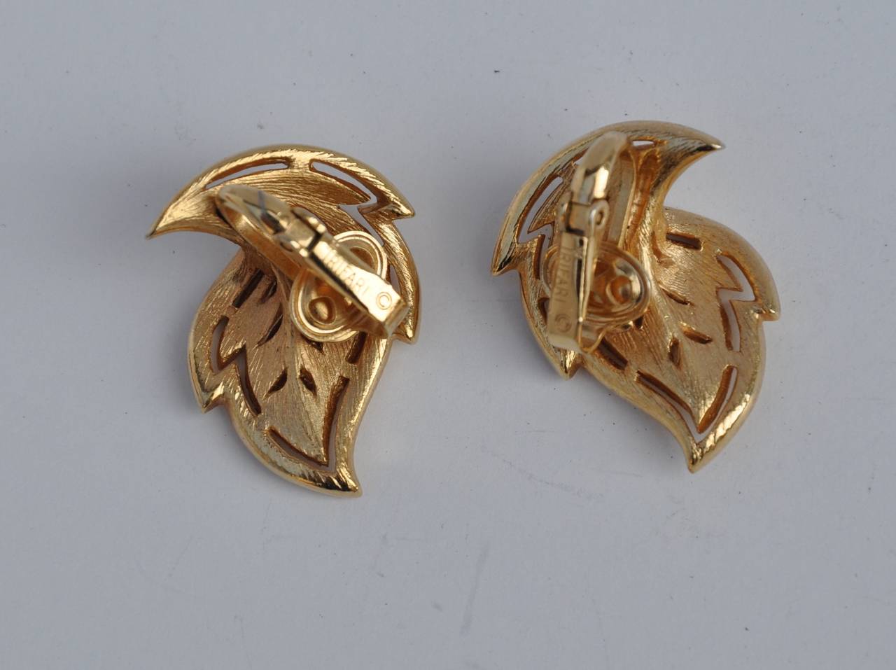 Trifari etched gilded gold tone "Leaf" ear clips measures 1" in height, 6/8" in width and 1/2" in depth. Earrings are signed on the backside.
