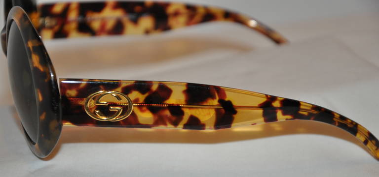 Les grandes lunettes de soleil rondes en écaille de Gucci sont dotées d'un verre vert teinté. La base des lunettes de soleil est composée d'une quincaillerie dorée et d'un revêtement en écaille de tortue.
   Le devant mesure 5 7/8