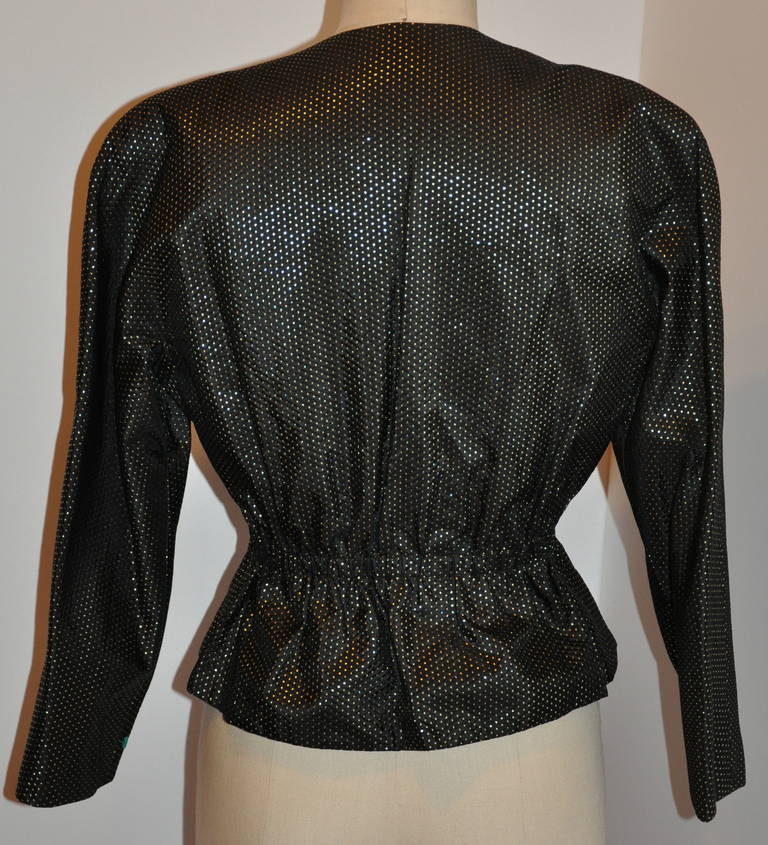 This wonderfully elegant and classic Halston evening jacket is fully lined with black silk. The exterior is black silk with metallic gold micro polka dots within. The waist has a gentle semi-elastic waist measuring 23