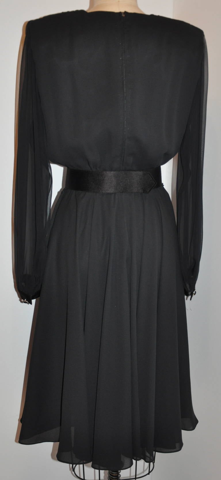 This wonderfully elegant and classic Ursula of Switzerland black evening dress is timeless in style and elegance. Wonderful draping of the neckline and sleeves. The dress has a center back zipper which measures 21 1/2