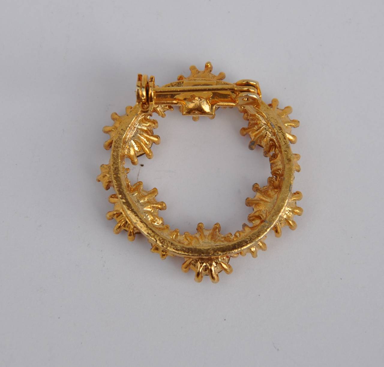Gilded gold vermeil accented with ruby rhinestones circular brooch measures 1 1/4" in circumference, depth is 2/8".