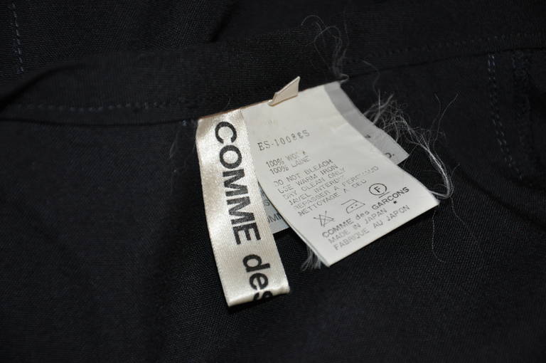 Comme des Garcons deconstructed dark navy wool skirt is sized small. When the skirt is unzippered, the waist measures 45 1/2