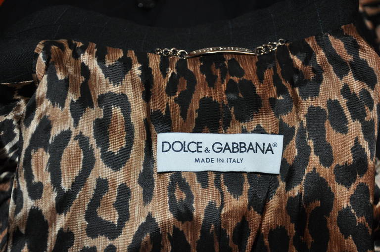 Dolce & Gabbana's spring wool, wonderfully classic, yet, wicked at the same time pantsuit in black has thin blue pinstripes. The lining has a whimisical wicked leopard silk lining. The jacket has a three button front with two set-in pockets on