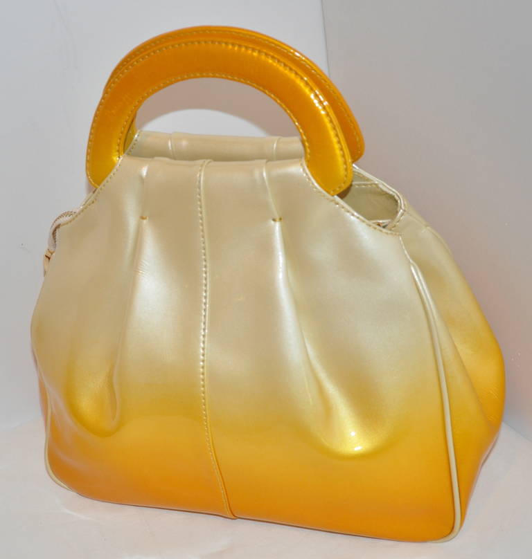 Roberto di Camerino's wonderful patent leather handbag with shades of the sunset (or sunrise) appears to be a simple handbag with a zipper top accented with gilded gold hardware of a 