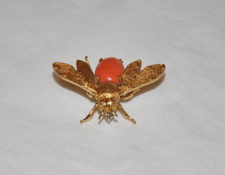 This wonderfully elegant and whimsical bee of 18K with coral has 6.1 grams of 18K.
   The brooch measures 1 1/2