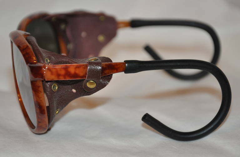 These mirrored sunglasses are accented with soft lambskin leather on the corners with random micro silver eyelets within. The arms features wrap-around for the ears for a better fit when wearing. Handmade in Japan, the rms are finished with black