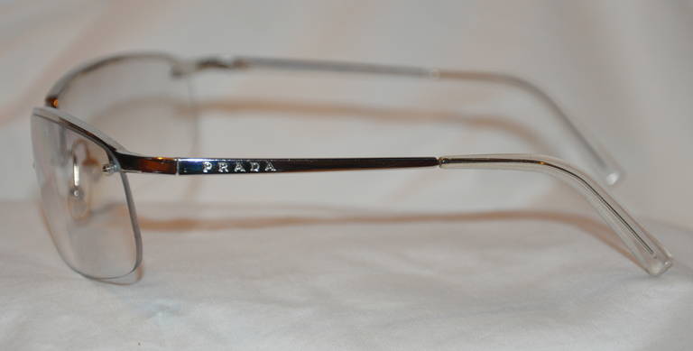 Prada semi-wrap-around glasses is combined with silver hardware and lucite. The front measures 5 3/4