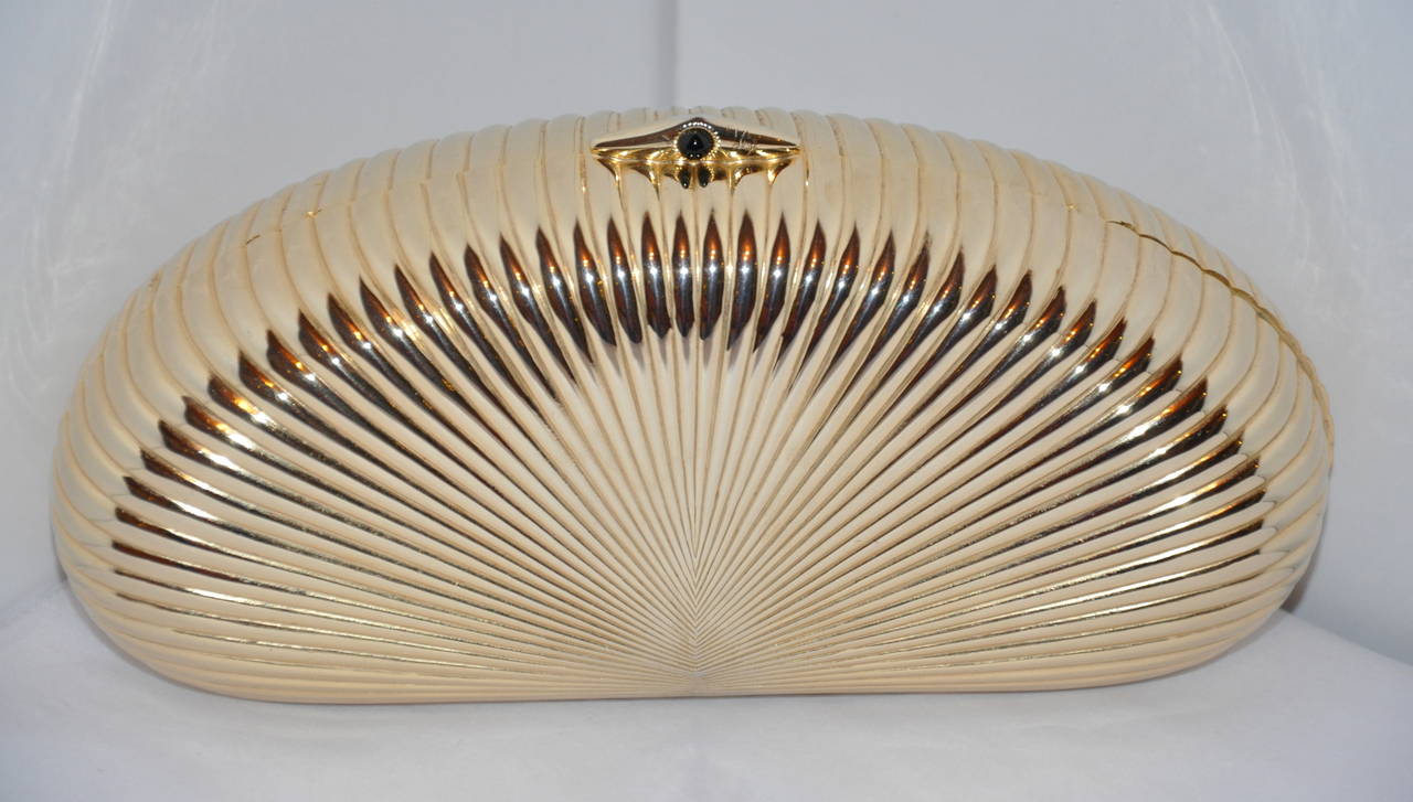 Burdines gilded gold hardware evening clutch has matchinh gilded gold hardware rope shoulder straps tucked inside for your desire.
   The opening snap located on top is centered with a single black stone.
   The length of the clutch measures 8
