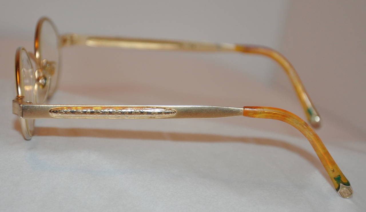 Masuda gilded gold titanium hardware frame eyeglasses is accented with etched gold hardware on the arms.
   The front measures 5 1/4
