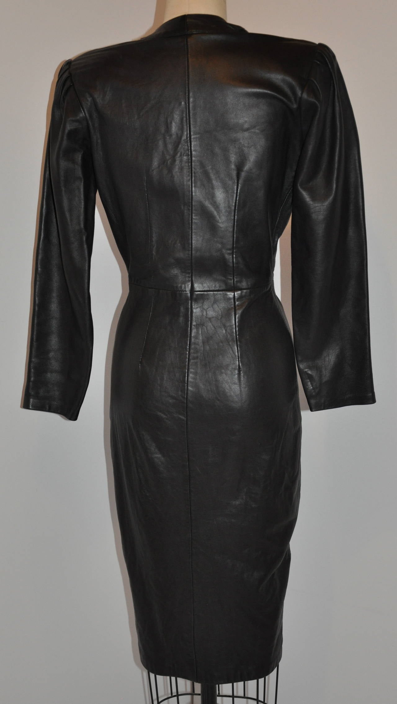 This wonderfully wicked Michael Hoban for North Beach Leather body-hugging dress is made with the softest lambskin leather and feels like butter when wearing. The front has twelve (12) black metal hardware snaps and detailed with padded shoulders